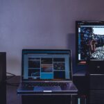 turned-on MacBook beside monitor